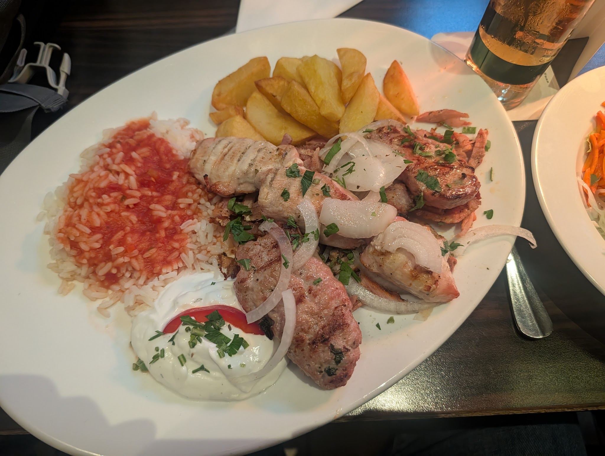 Gegrilltes Fleisch mit Reis, Pommes und Tzatziki